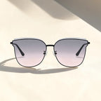 Flat lay studio shot of AvilaDubee DB7242 cat eye sunglasses, matte black stainless steel frame ash pink gradient UV400 nylon lenses soft shadow minimalist product display