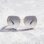AvilaDubee DB7258 rose gold square sunglasses with mist grey gradient UV400 lenses placed on textured concrete background, chic minimalist women fashion sunglasses for photoshoots