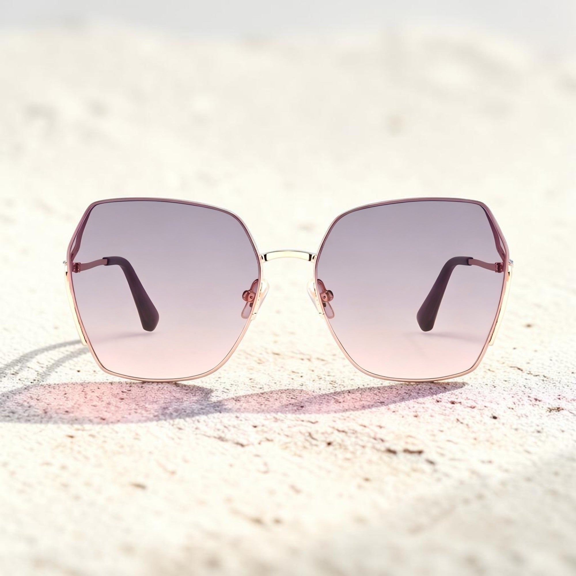 Beach sand texture background photo of AvilaDubee DB7258 rose gold square sunglasses, lavender gradient tint UV400 lenses ideal for summer vacation and beach travel outfits