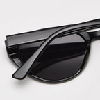 Close-up side detail shot of retro cat eye sunglasses with glossy black TR90 frame, showing smooth temple texture and curved lens rim on plain white background