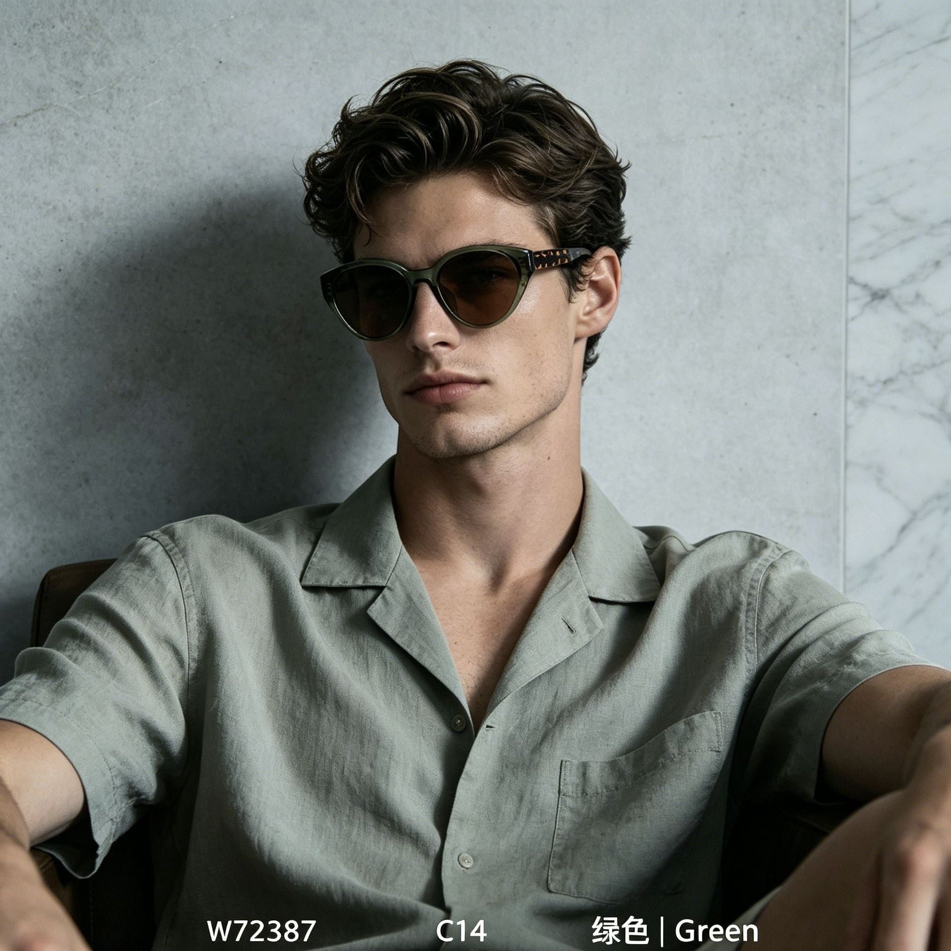 Man in sage linen shirt wearing retro cat eye green frame sunglasses, relaxed indoor casual fashion shot